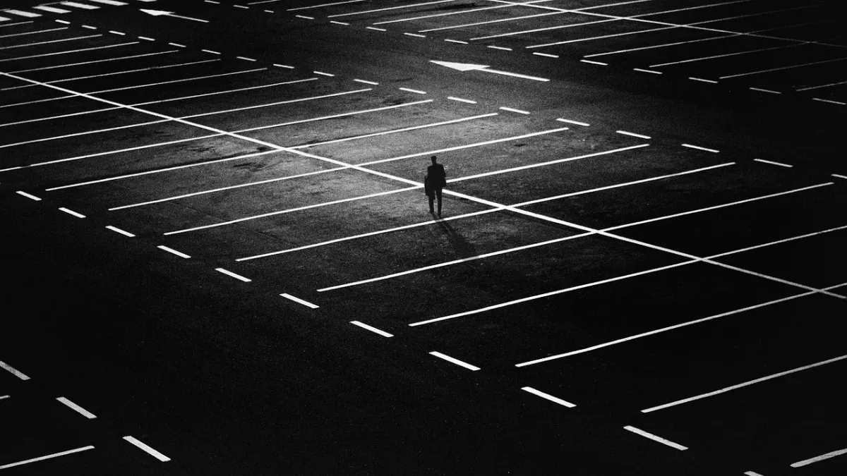 Mężczyzna słuchający audiobooka na parkingu w centrum miasta.